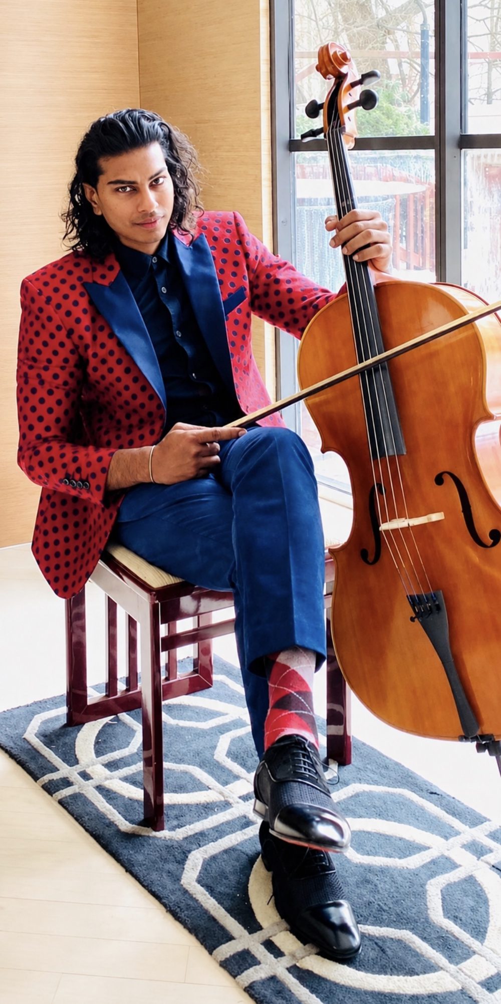 Travis Darshan holding a cello
